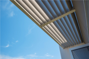 Exterior window awning providing shade against a blue sky