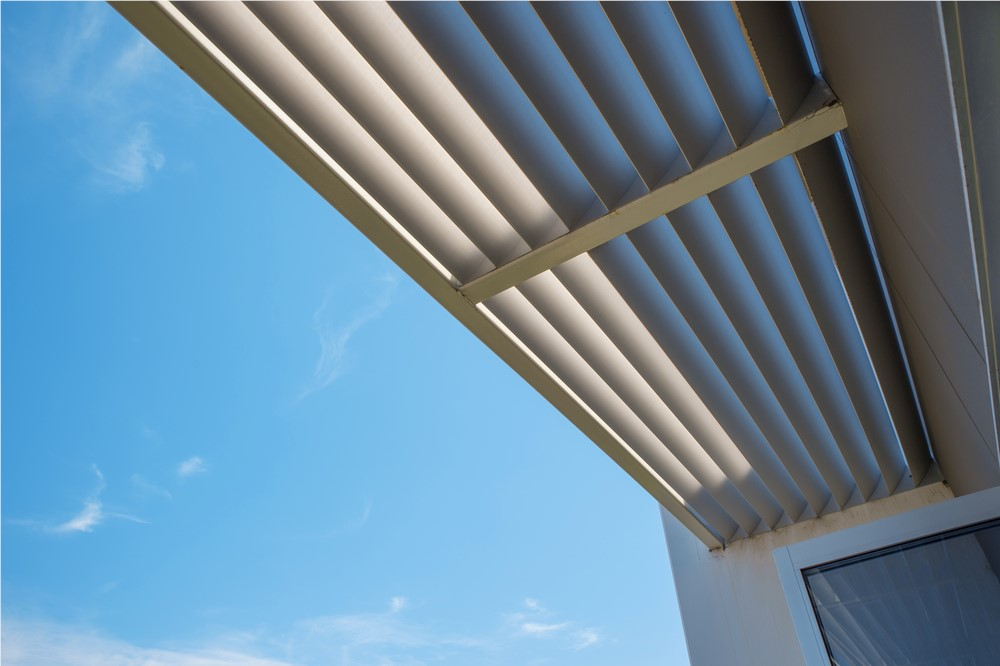 Exterior window awning providing shade against a blue sky