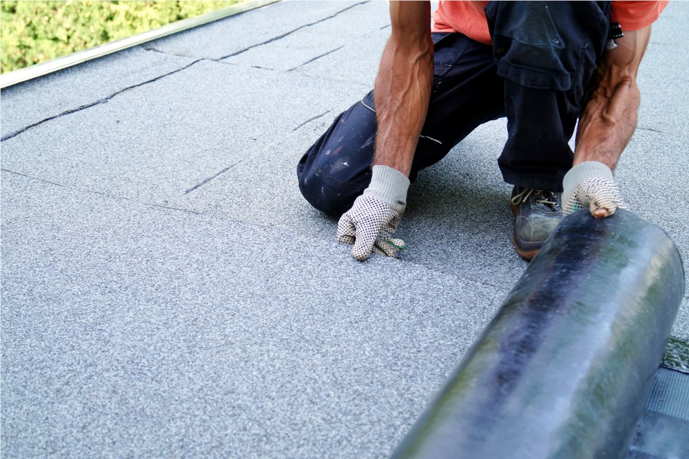 Technician installing a flat low-slope membrane roof system