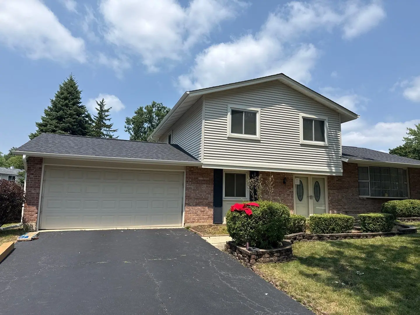 Bolingbrook home with gray siding, a shingle roof and an attached two-car garage