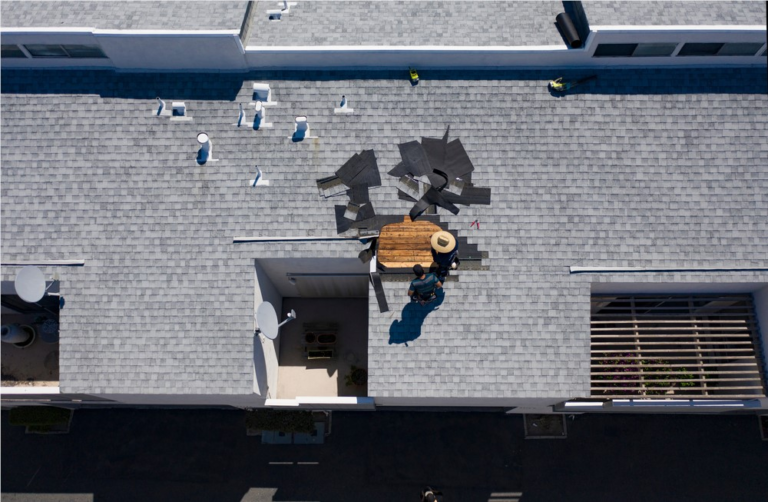 Roofer performing a targeted roof repair on damaged shingles and flashing
