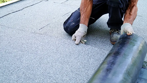 Technician installing a flat low-slope membrane roof system