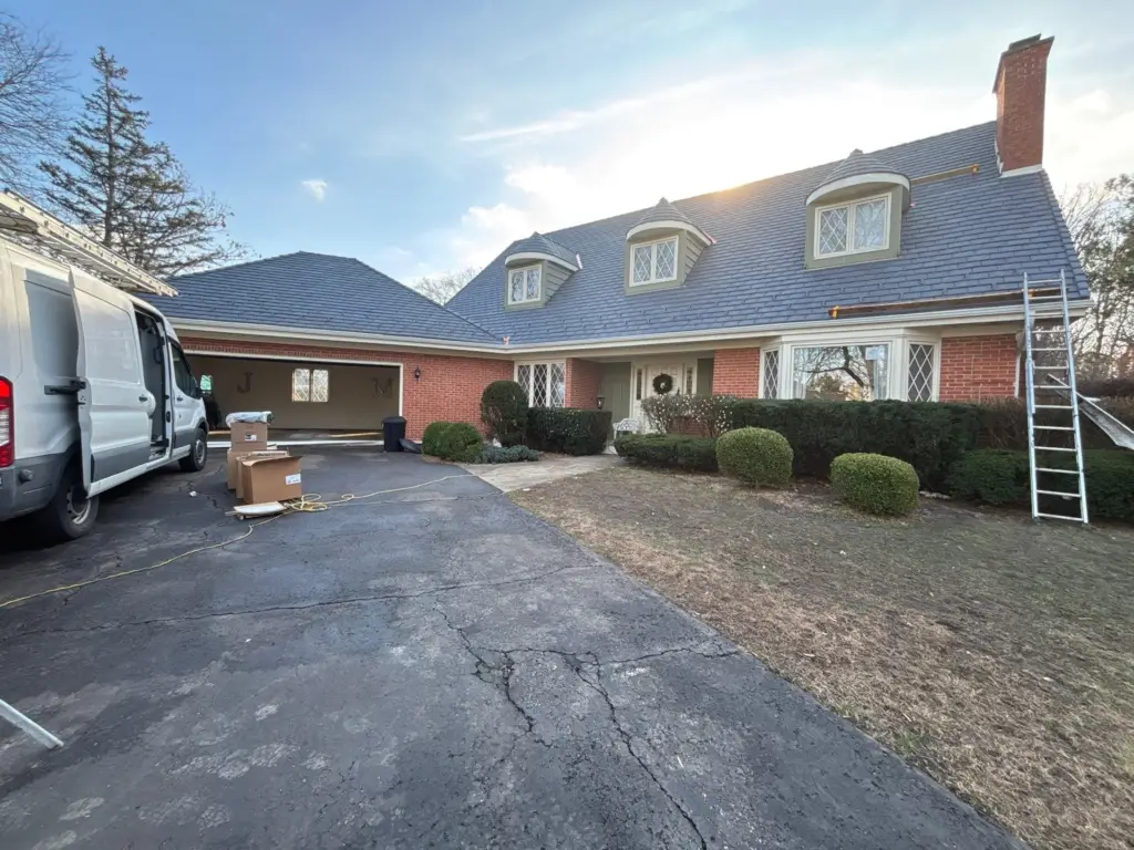 Gray DaVinci synthetic slate roof on a brick home with dormers